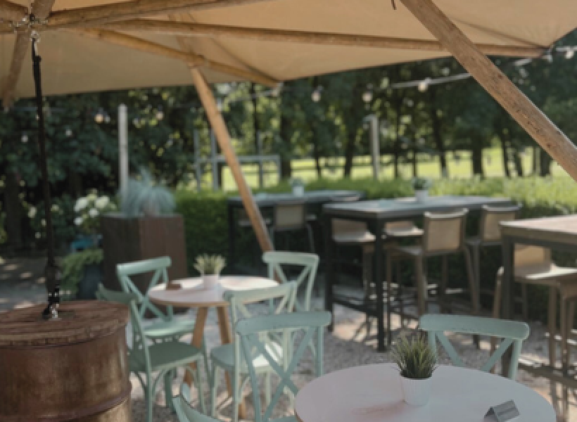 Het terras van Brasserie Rhoonse Polder met uitzicht over de golfbaan